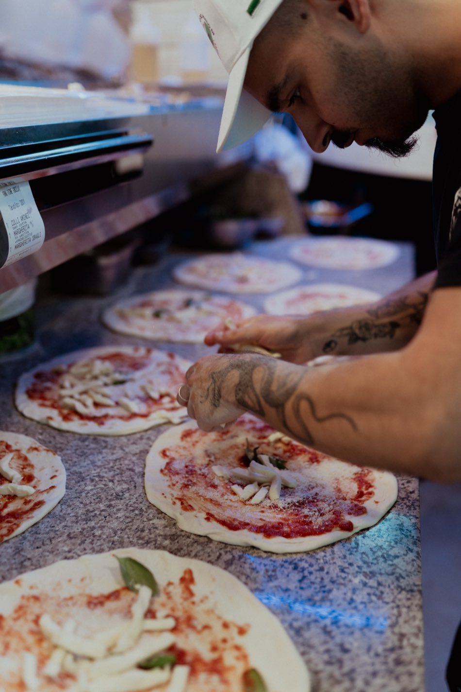 Il pizzaiolo prepara la pizza sul banco