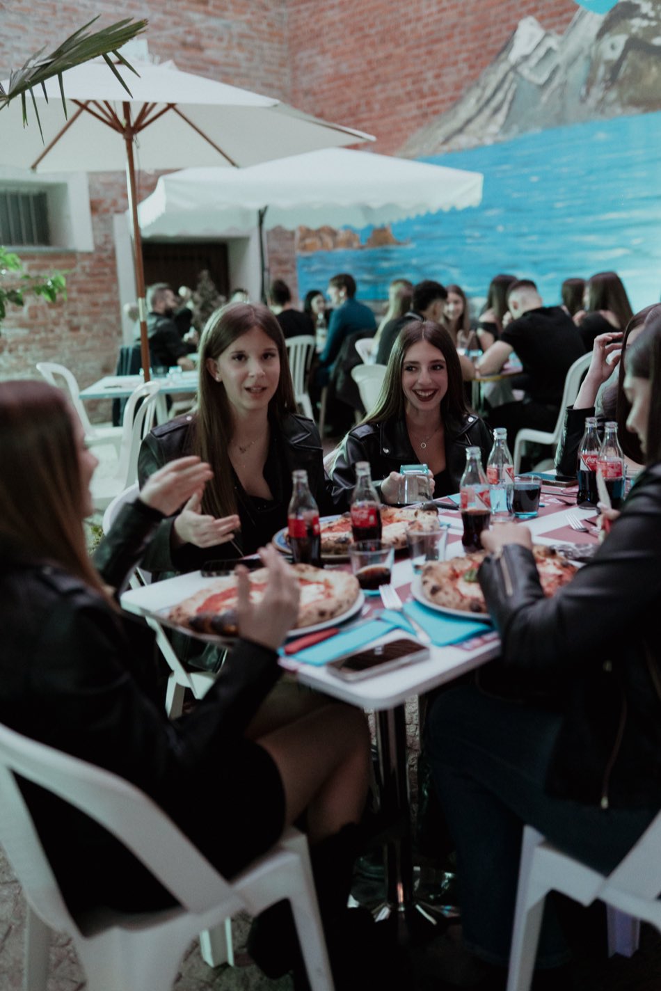 Amiche a cena ai tavoli all'aperto