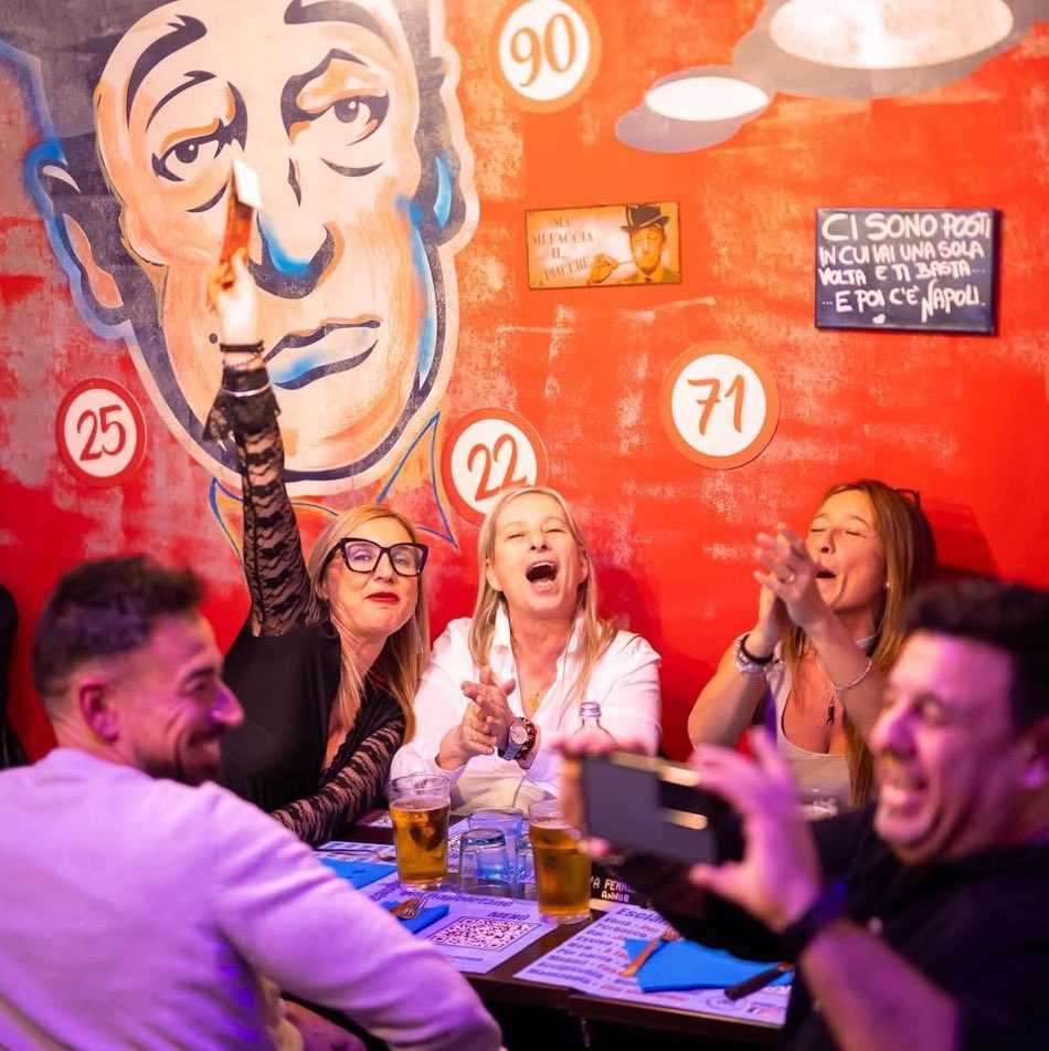Risate ai tavoli sotto i murales